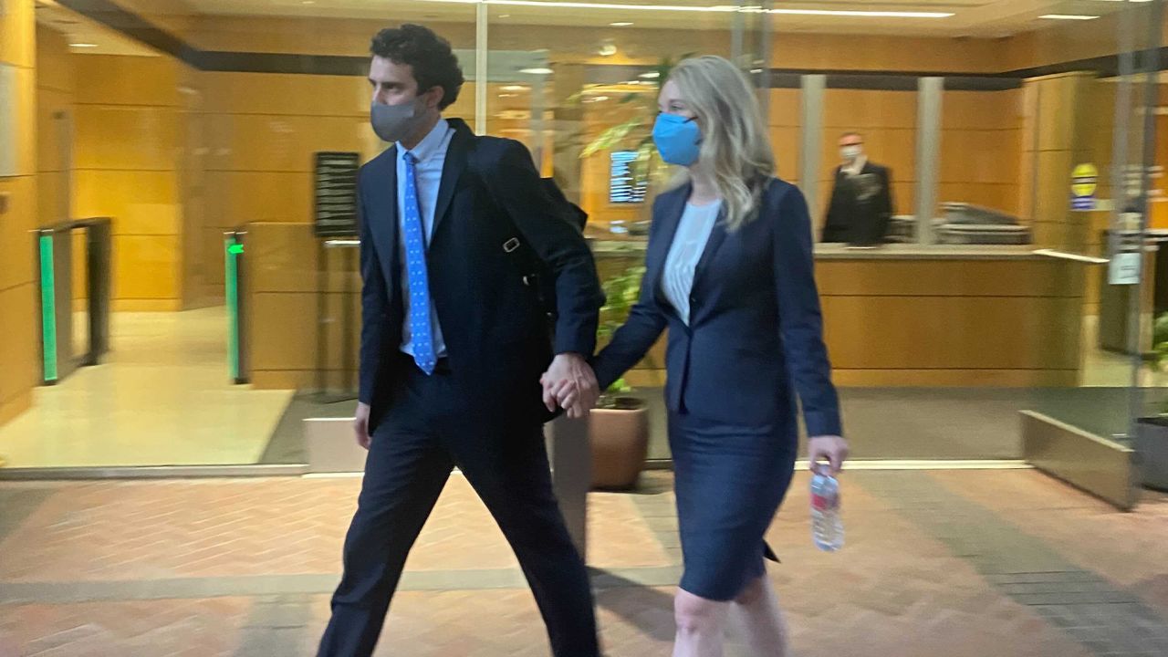 Elizabeth Holmes leaves a San Jose courtroom with her partner after her first testimony.