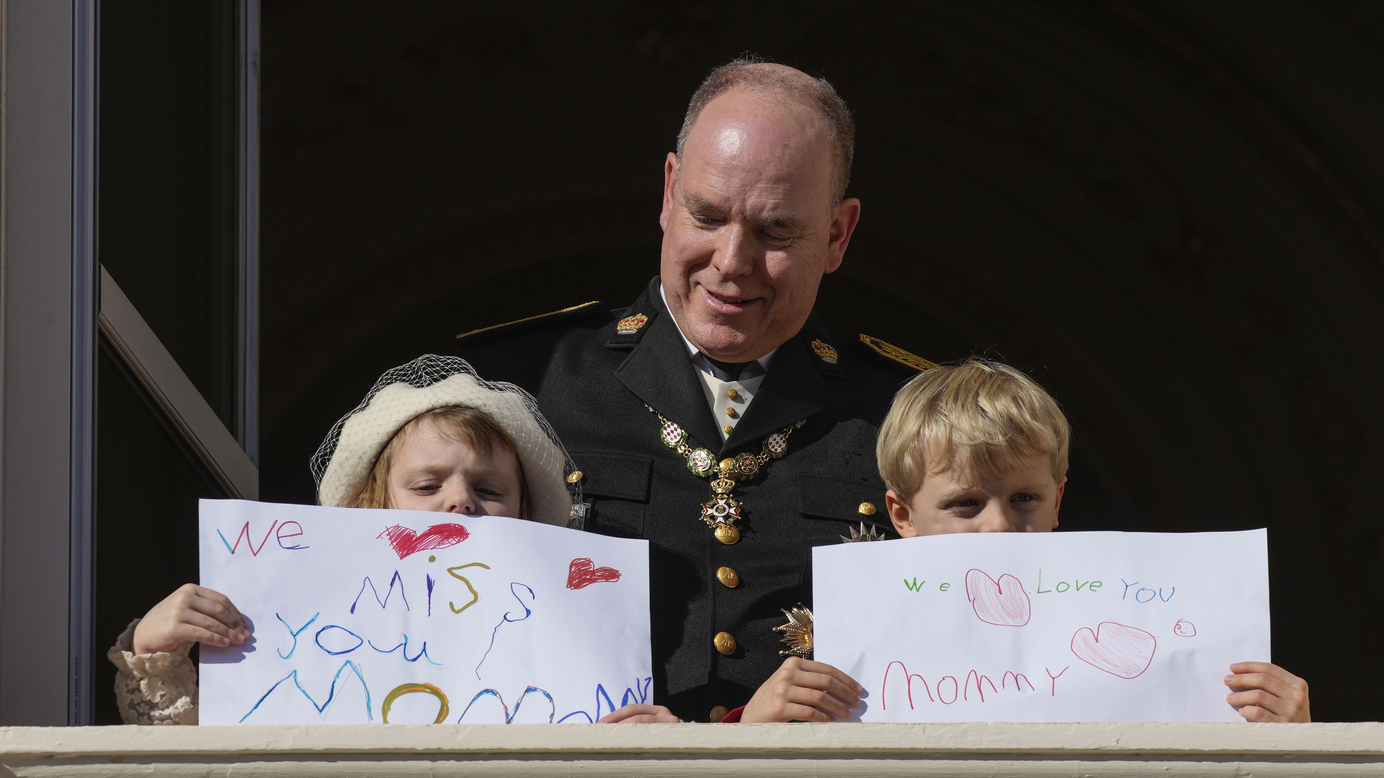 Princess Gabriella and Prince Jacques hold signs for their mother on the balcony of the the Monaco Palace during ceremonies marking National Day.