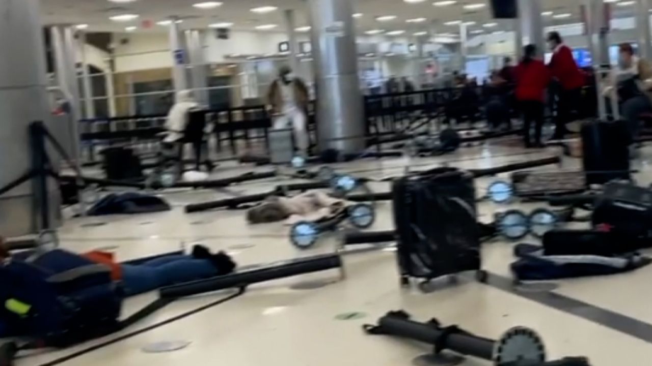 A still image taken from a video shared by a witness shows airport stanchions knocked over where passengers were previously waiting in line.