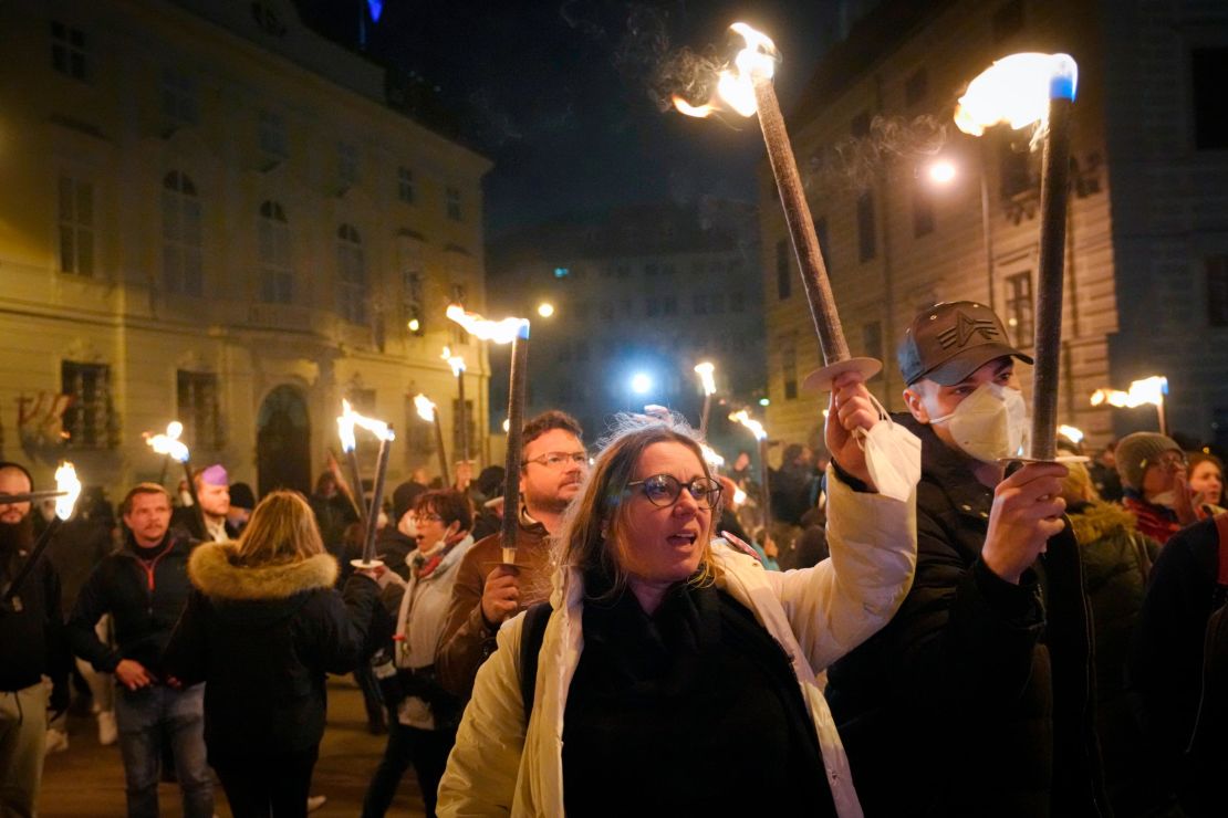 Anti-lockdown protesters hold torches in Vienna, Austria on Saturday.