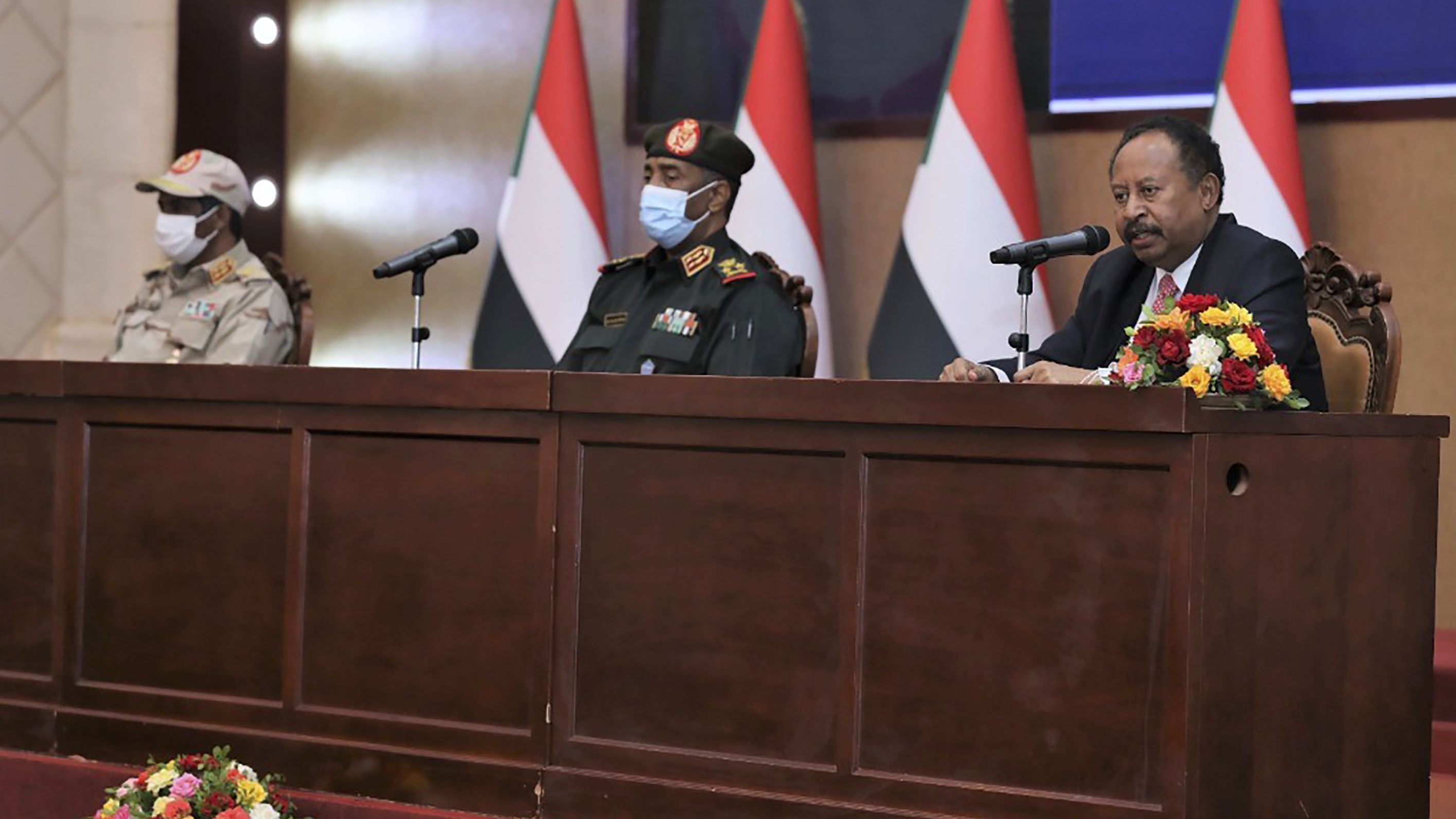 Prime Minister Abdalla Hamdok sits next to Sudan's top general, Abdel Fattah Al-Burhan, as he speaks at a ceremony that reinstated him in Khartoum, Sudan, on November 21, 2021.