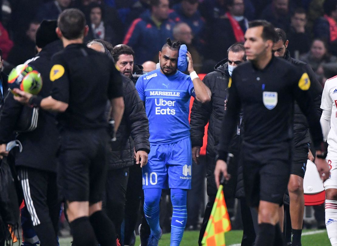 Payet leaves the field after having received treatment from being hit by a water bottle thrown from the stands during the Lyon and Marseille match.