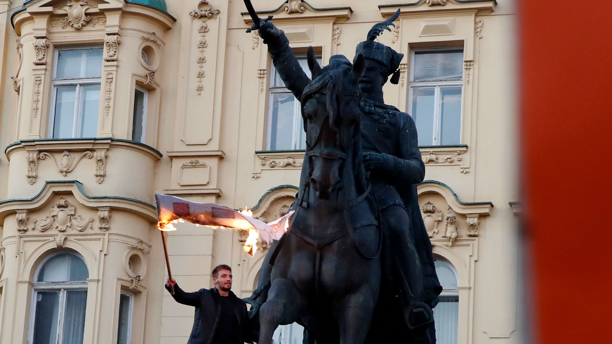 A man burns a flag during a protest in Zagreb, Croatia, on Saturday. Around 15,000 people were protesting the Croatian government's coronavirus measures. From Monday, only people with Covid passports can enter government and public buildings in Croatia.