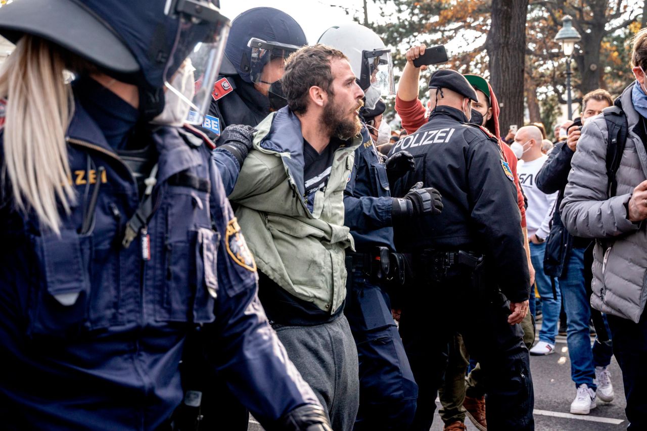 A man is detained by police during protests in Vienna on Saturday. More than 1,400 police officers were deployed across Austria to maintain public order, according to a police statement.