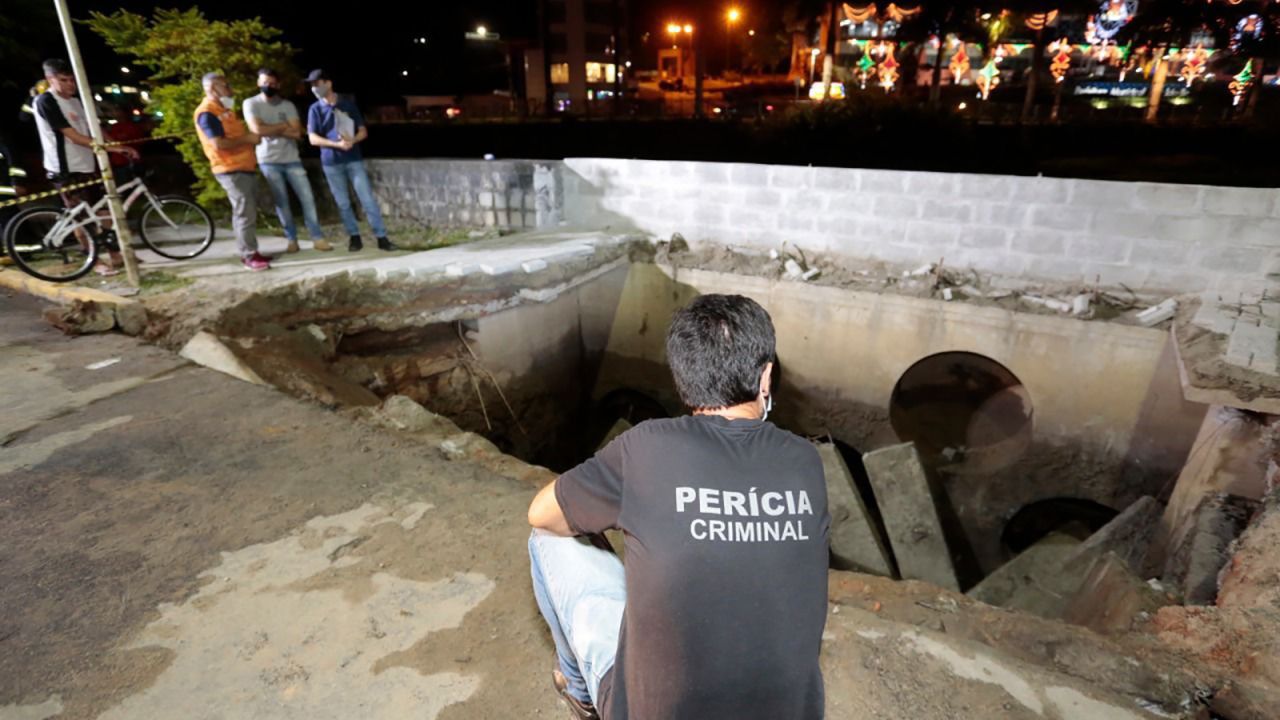 Officials survey the scene after a sidewalk collapsed in the city of Joinville on Monday.