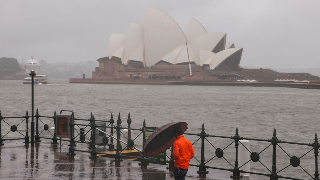 SYDNEY, AUSTRALIA - MARCH 23: A man walks to work in Circular Quay carrying an umbrella to shelter from the driving rain on March 23, 2021 in Sydney, Australia. Evacuation warnings are in place for parts of Western Sydney as floodwaters continue to rise. (Photo by David Gray/Getty Images)