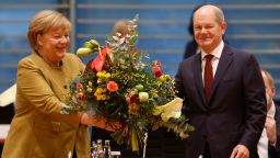 BERLIN, GERMANY - NOVEMBER 24: Acting Chancellor Angela Merkel receives a bouquet of flowers from acting Finance minister and Vice Chancellor Olaf Scholz as she arrives for the weekly government cabinet meeting on November 24, 2021 in Berlin, Germany. Germany is currently struggling through the fourth wave of the coronavirus pandemic that has sent Covid infection rates to record highs in recent weeks. (Photo by Michele Tantussi/Getty Images)