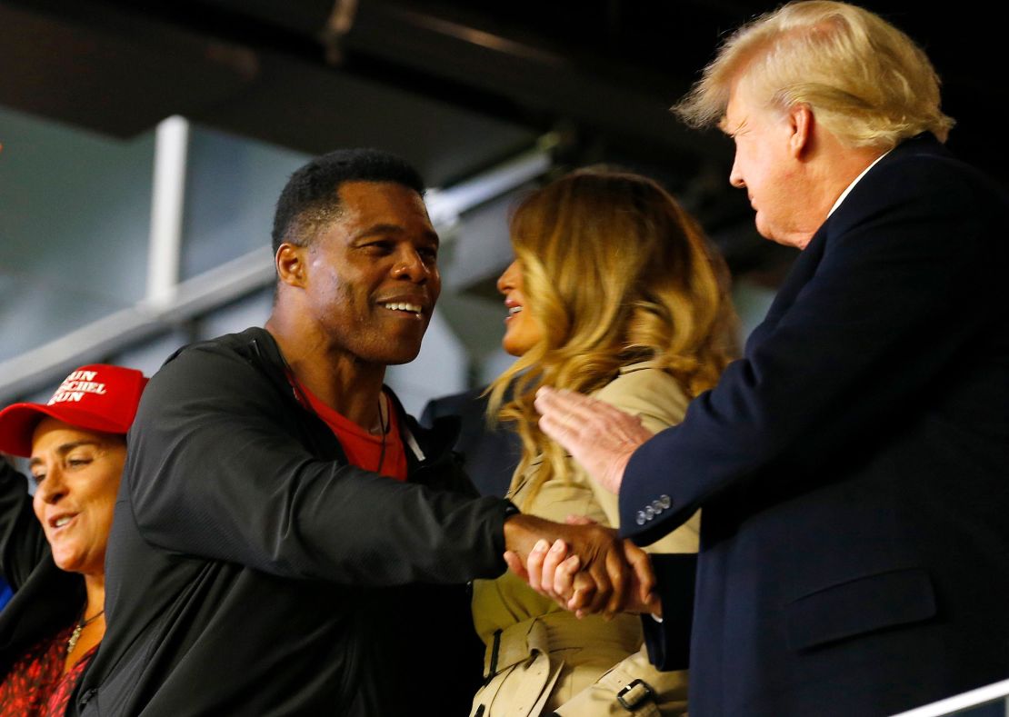 Former football player and political candidate Herschel Walker interacts with former president of the United States Donald Trump prior to Game Four of the World Series between the Houston Astros and the Atlanta Braves Truist Park on October 30 in Atlanta, Georgia. 