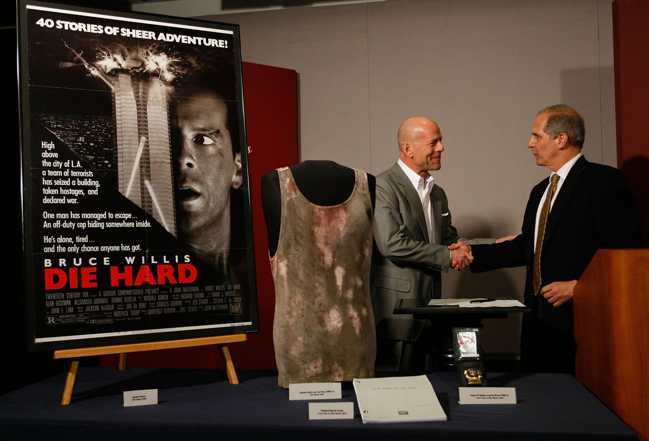 Bruce Willis presenting the National Museum of American History with props from the "Die Hard" series in 2007, including a tank top from the first film. 