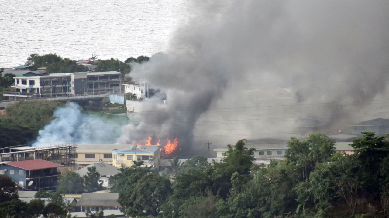 Smoke rises from buildings in Honiara on the Solomon Islands on November 25, on the second day of rioting that left the capital ablaze and threatened to topple the Pacific nation's government.