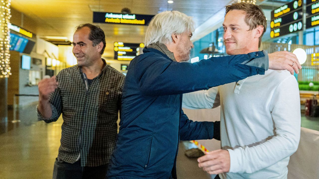 NRK journalists Halvor Ekeland (right) and Lokman Ghorbani (left) are welcomed by head of NRK sports Egil Sundvor in Gardermoen on November 24 after returning from Qatar.