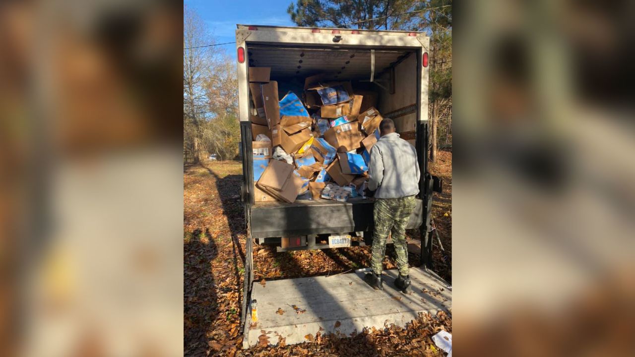 Hundreds of packages thrown into an Alabama ravine are loaded onto a truck Thursday, November 25, 2021. 