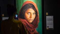 A visitor takes photos of a 1985 National Geographic magazine cover "Afghan Girl" Sharbat Gula displayed at the National Geographic Exhibition in Xi'an city, northwest China's Shaanxi province, 19 September 2017.The National Geographic Exhibition kicked off in Xi'an city, northwest China's Shaanxi province, 19 September 2017. The show includes many of the best photos to run in the magazine since it was first published in 1888, including some from remote corners of the planet.