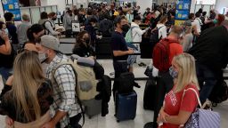 People wait in the line to clear through the TSA checkpoint at Miami International Airport on November 24, 2021 in Miami, Florida. The Transportation Security Administration is expecting airline passenger numbers to reach pre-pandemic level the day before Thanksgiving, one of the busiest days at airports across the country. 