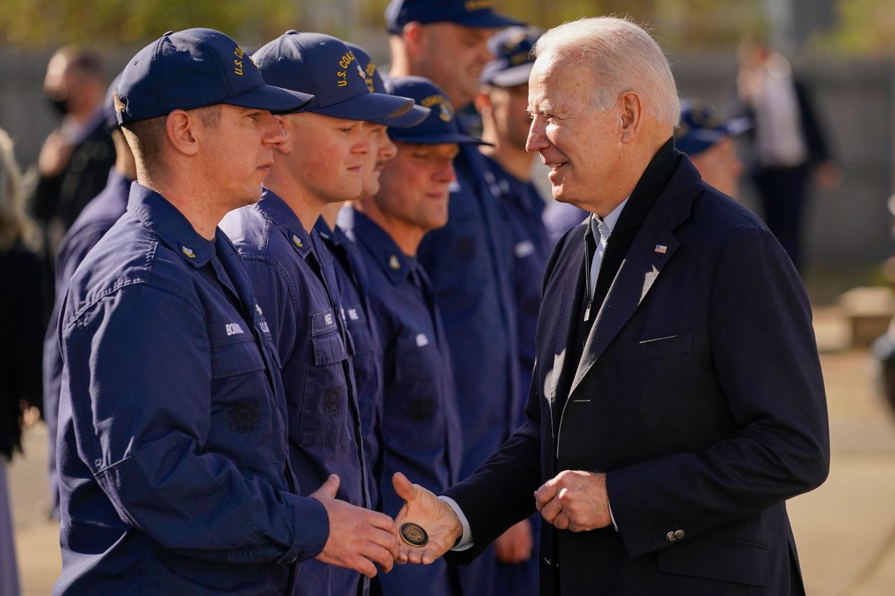President Joe Biden passes a challenge coin to a member of the US Coast Guard while in Nantucket, Massachusetts, on Thursday. Biden also met virtually with service members around the world to thank them for their service and wish them a happy Thanksgiving.