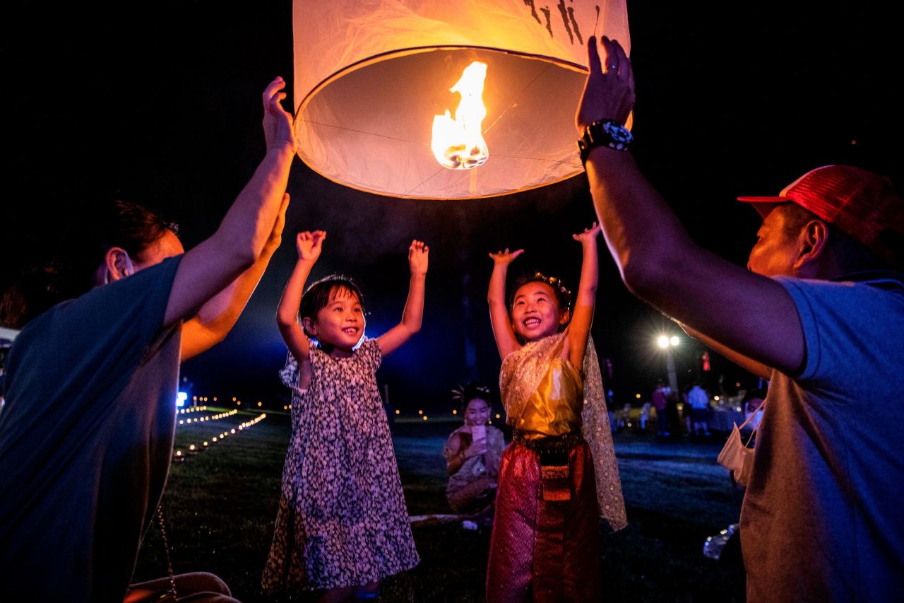 Children help launch lanterns into the sky during the Yee Peng festival of lights in Lamphun, Thailand, on Saturday, November 20.