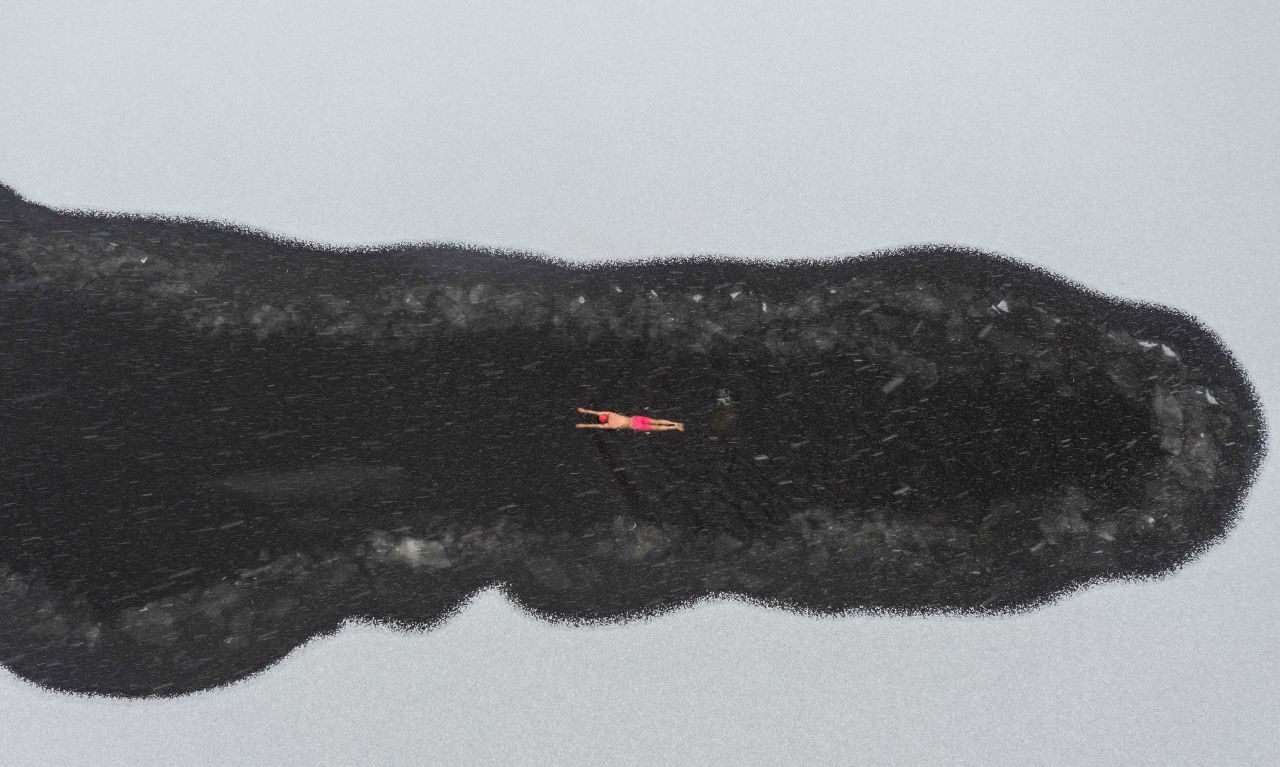 A man swims in a partially frozen lake in Shenyang, China, on Monday, November 21.
