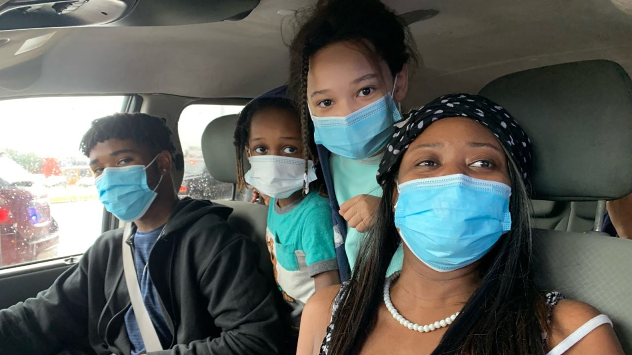 Tiffany Bernard, right, picks up food from the George R. Brown Convention Center in Houston with three of her five children.