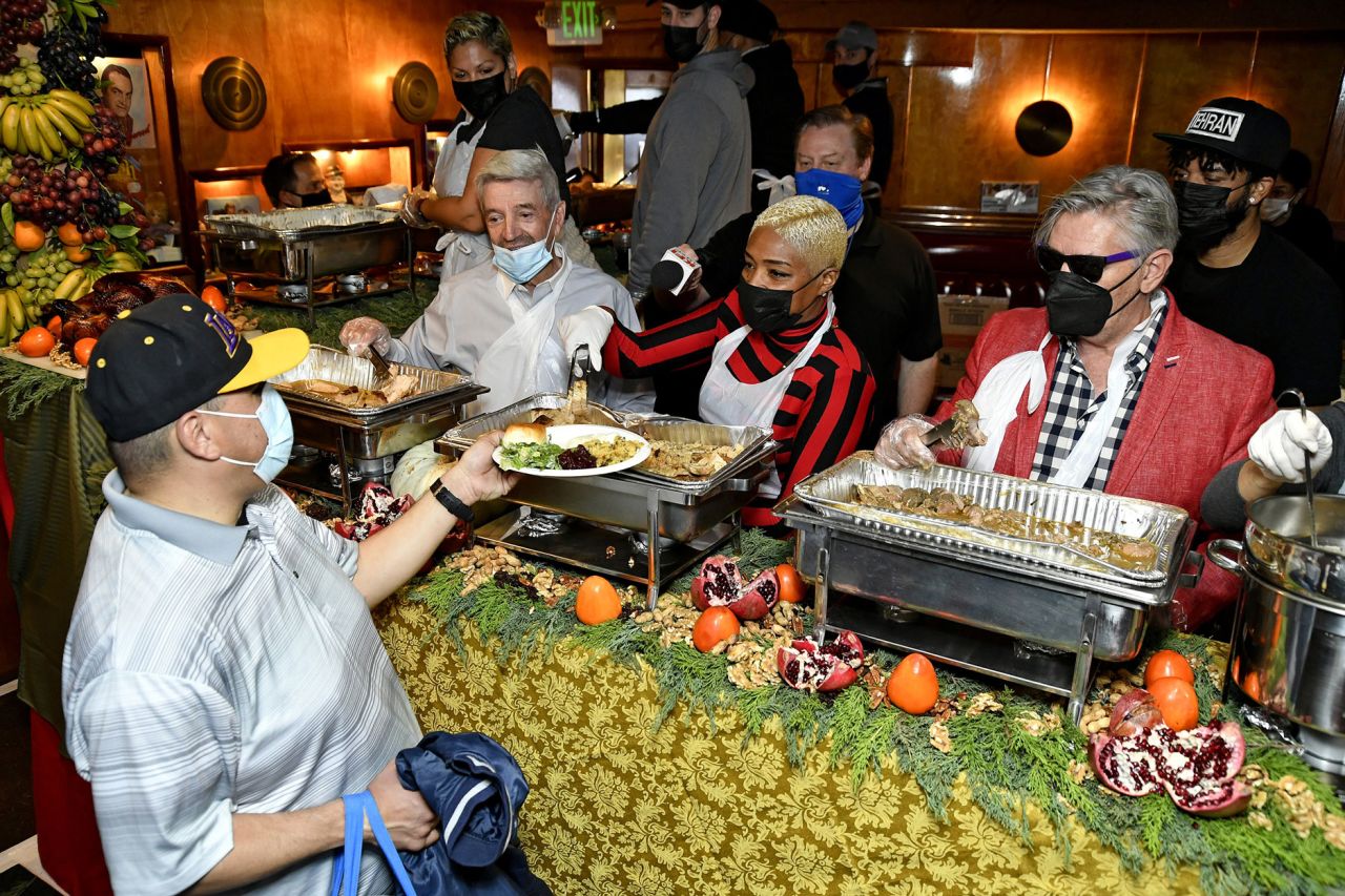 Comedians Tom Dreesen, Tiffany Haddish and Frazer Smith serve food at the Laugh Factory's free Thanksgiving dinner in West Hollywood, California.