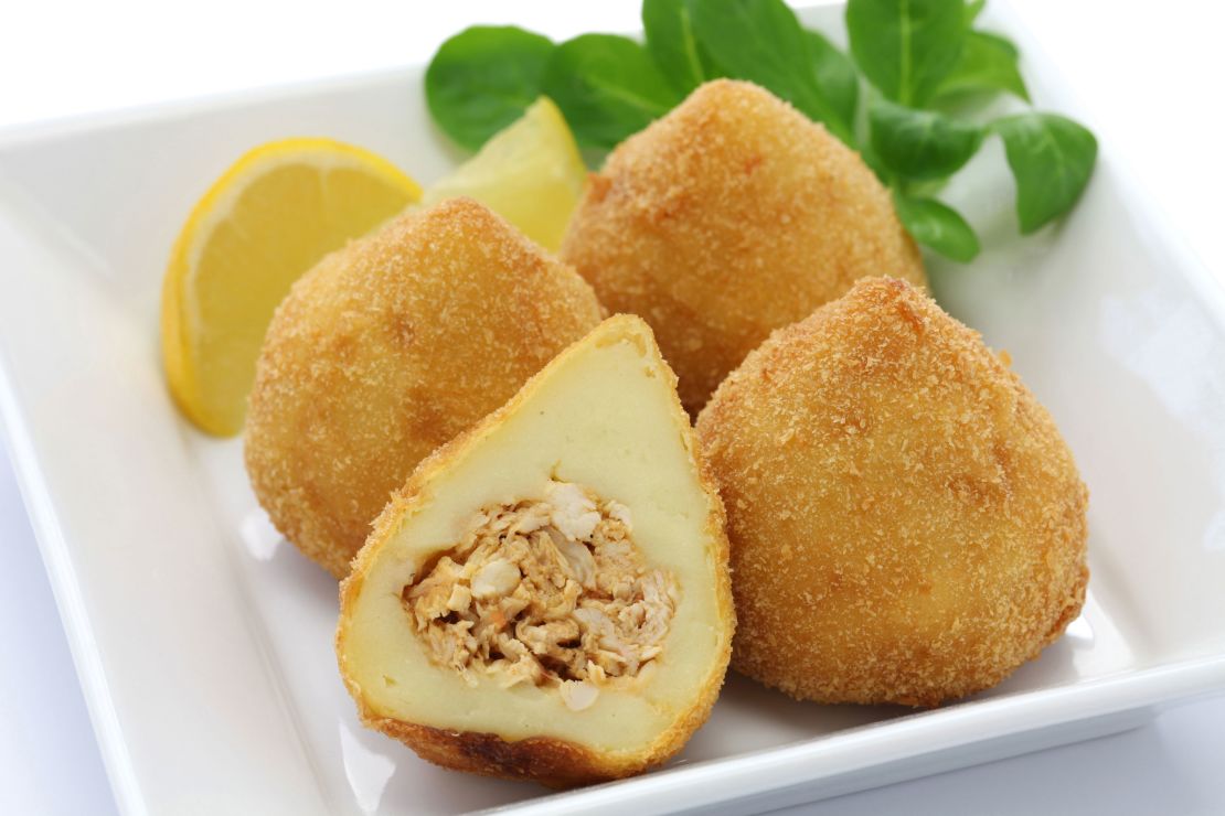 Coxinha are fried dough balls with shredded chicken inside.