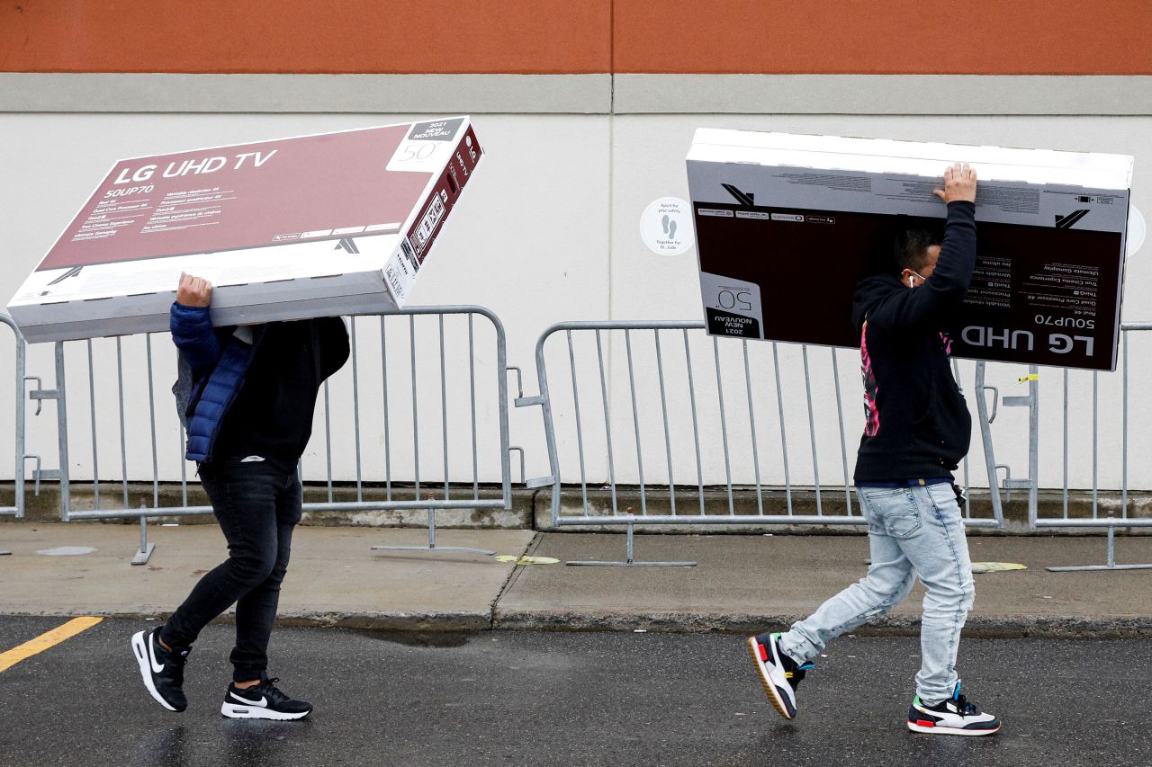 Shoppers carry televisions as they exit a Best Buy store in Brooklyn, New York, on Friday.