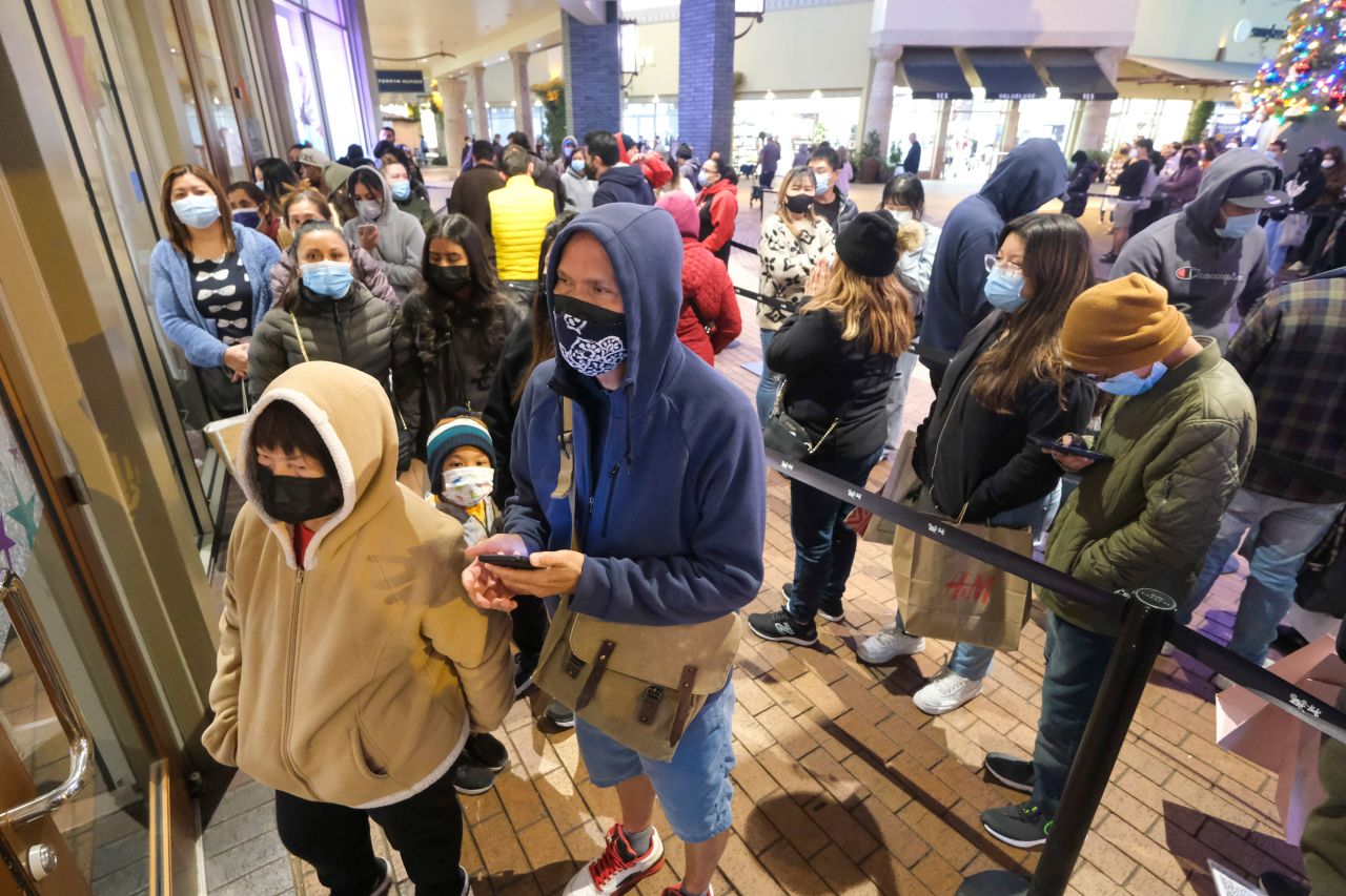 People wait in line Friday to enter a store at the Citadel Outlets in Commerce, California.