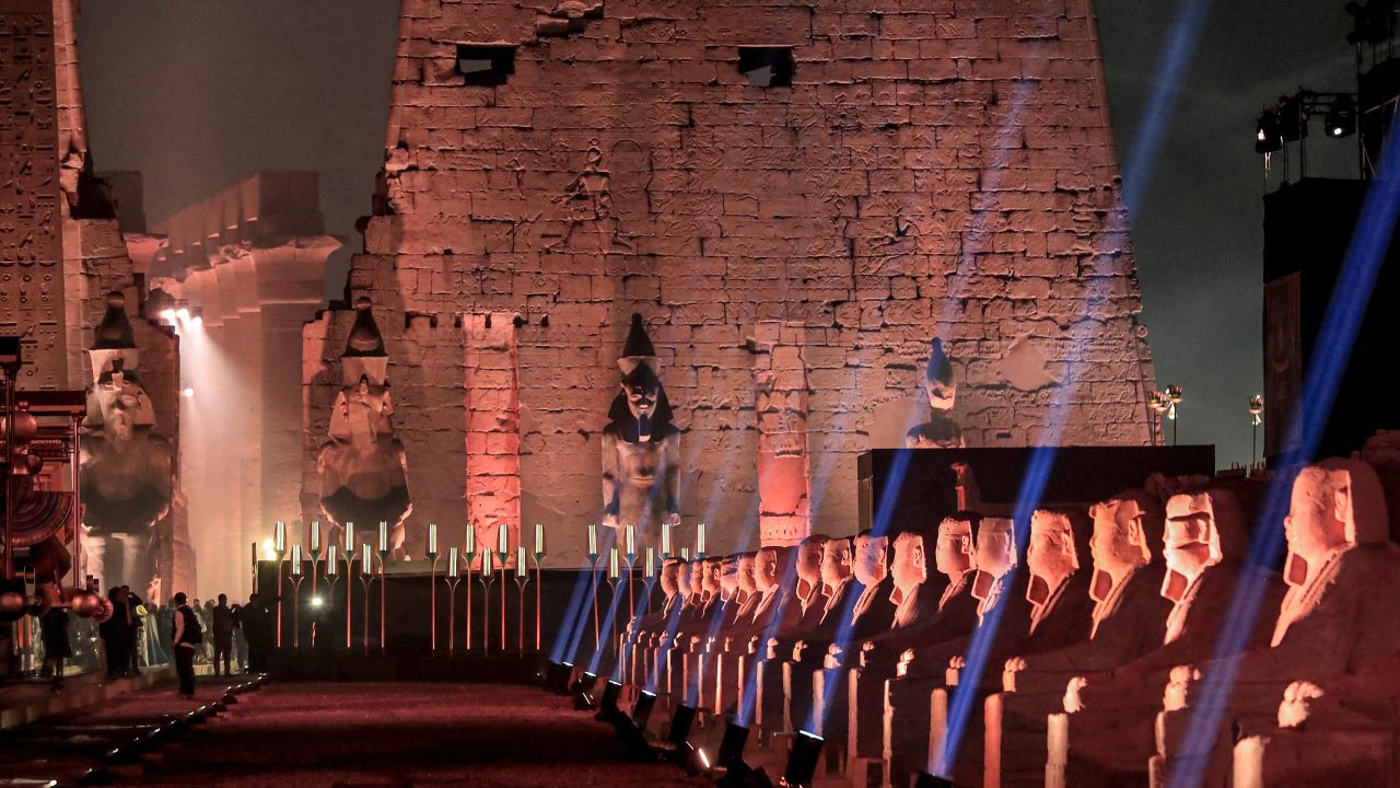This picture taken on November 25, 2021 shows a view of the human-headed sphinxes along the 2700-metre-long "Rams Road" (Sphinx dromos) leading from the Temple of Luxor (background) to the Karnak Temple (unseen) further north, in Egypt's southern city of the same name. - Egypt on November 25 unveiled in a grandiose night-time ceremony the "Rams Road" (Tareeq al-Kebbash in Arabic), a 2700-metre-long sandstone-paved path lined with ram-headed statues and sphinxes dating over 3000-years-old connecting the Luxor Temple with the Karnak Temple. Named "The Path of God" in Ancient Egyptian mythology, its ram statues -- an embodiment of the ancient Egyptian deity Amun -- were buried for centuries under the sand before being revived and restored for display in recent years. (Photo by Khaled DESOUKI / AFP) (Photo by KHALED DESOUKI/AFP via Getty Images)