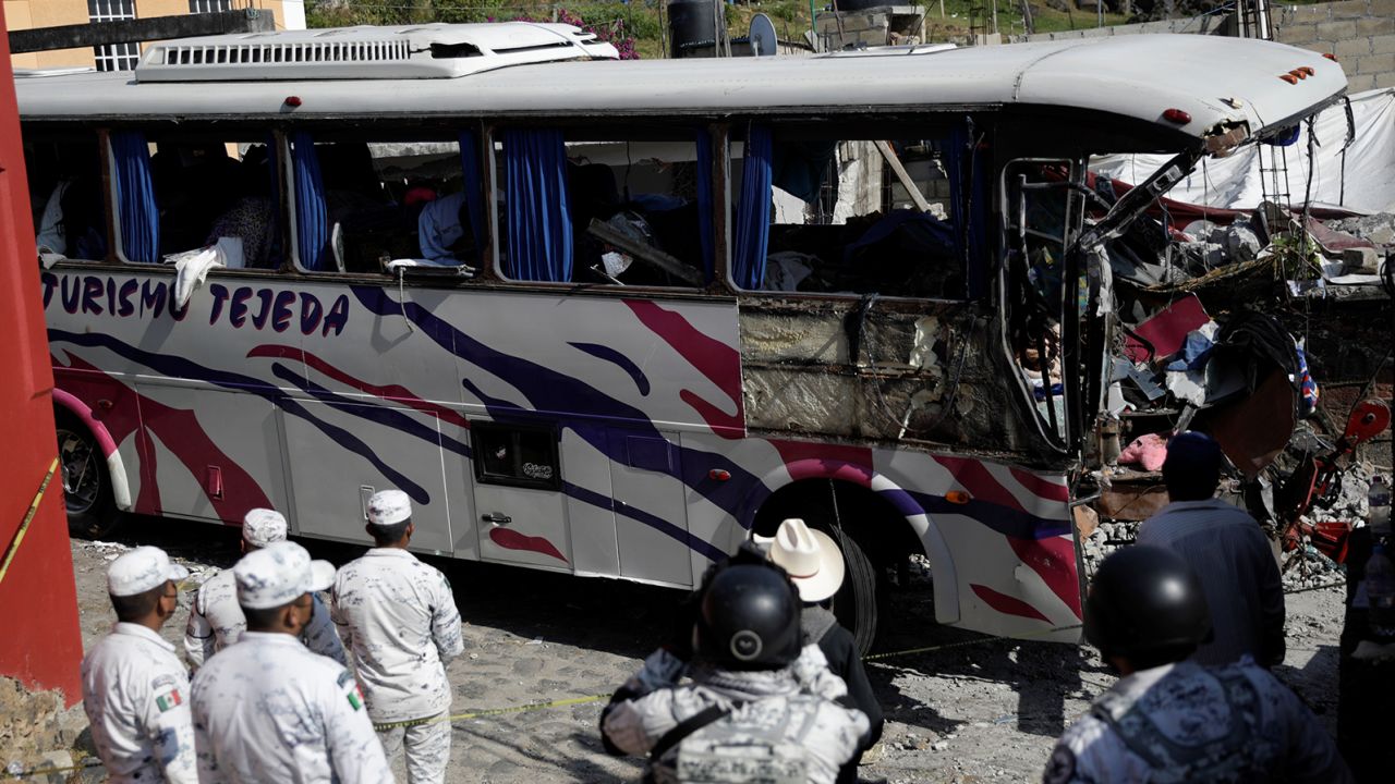 Members of Mexico's National Guard stand near the scene where at least 19 people were killed after a passenger bus traveling on a highway crashed into a house in San Jose El Guarda, Mexico on November 26.
