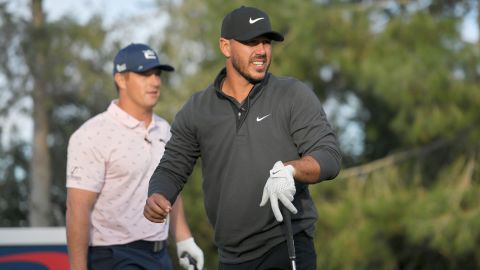 Brooks Koepka plays his shot from the 10th tee as Bryson DeChambeau looks on during Capital One's "The Match" at Wynn Golf Course on November 26, 2021 in Las Vegas, Nevada.