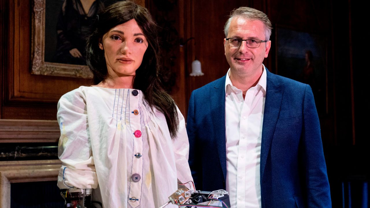 Aidan Meller poses with Ai-Da during a launch event for its first solo exhibition in Oxford on June 5, 2019.