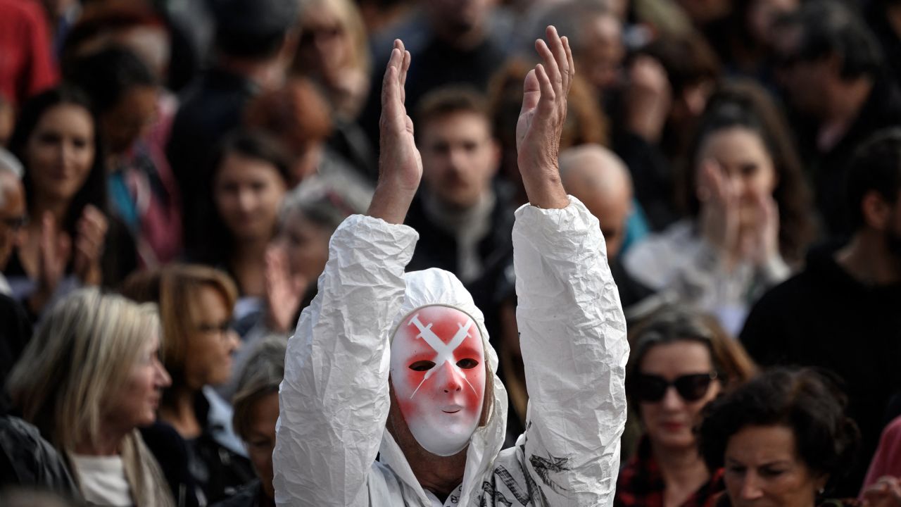 A protester wearing a mask depicting syringes applauds in Geneva, Switzerland, on October 9, 2021, during a rally against coronavirus measures.