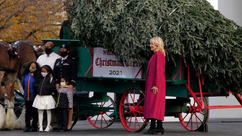 First lady Jill Biden, right, and DC Army National Guard Capt. Maryanne V. Harrell and her family pose for a photo with the official 2021 White House Christmas Tree, grown in North Carolina, as it arrives at the White House on Nov. 22, 2021.