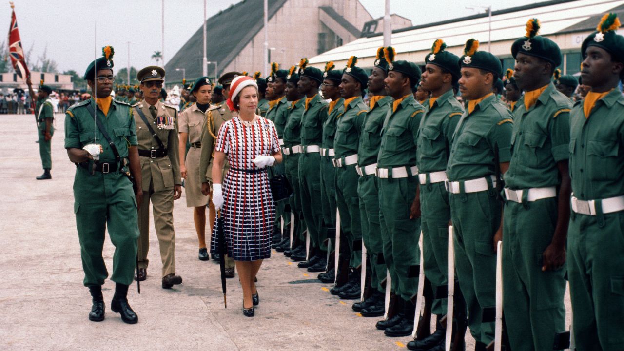 The Queen inspects an honor guard as she arrives in Barbados on October 31, 1977.