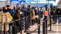 Travelers wait in line at a security checkpoint at Reagan National Airport in Arlington, Virginia, USA, 24 November 2021.
