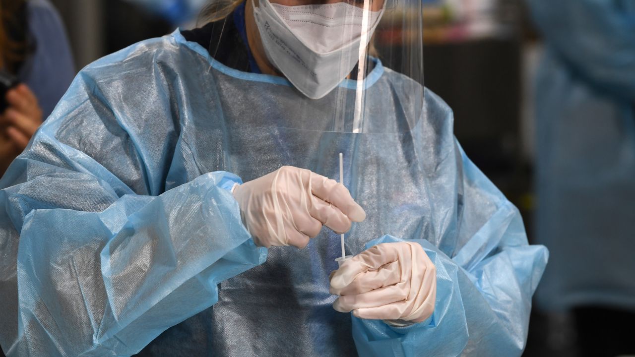 A health staff member prepares a COVID-19 test at the Histopath Diagnostic Specialists pre-departure area at Sydney International Airport on November 28, 2021 in Sydney, Australia. NSW Health authorities will now send people who have been overseas in the two weeks before their arrival into three days of home quarantine, as the state works out its response to the threat posed by a new, "concerning" variant of COVID-19 named Omicron.