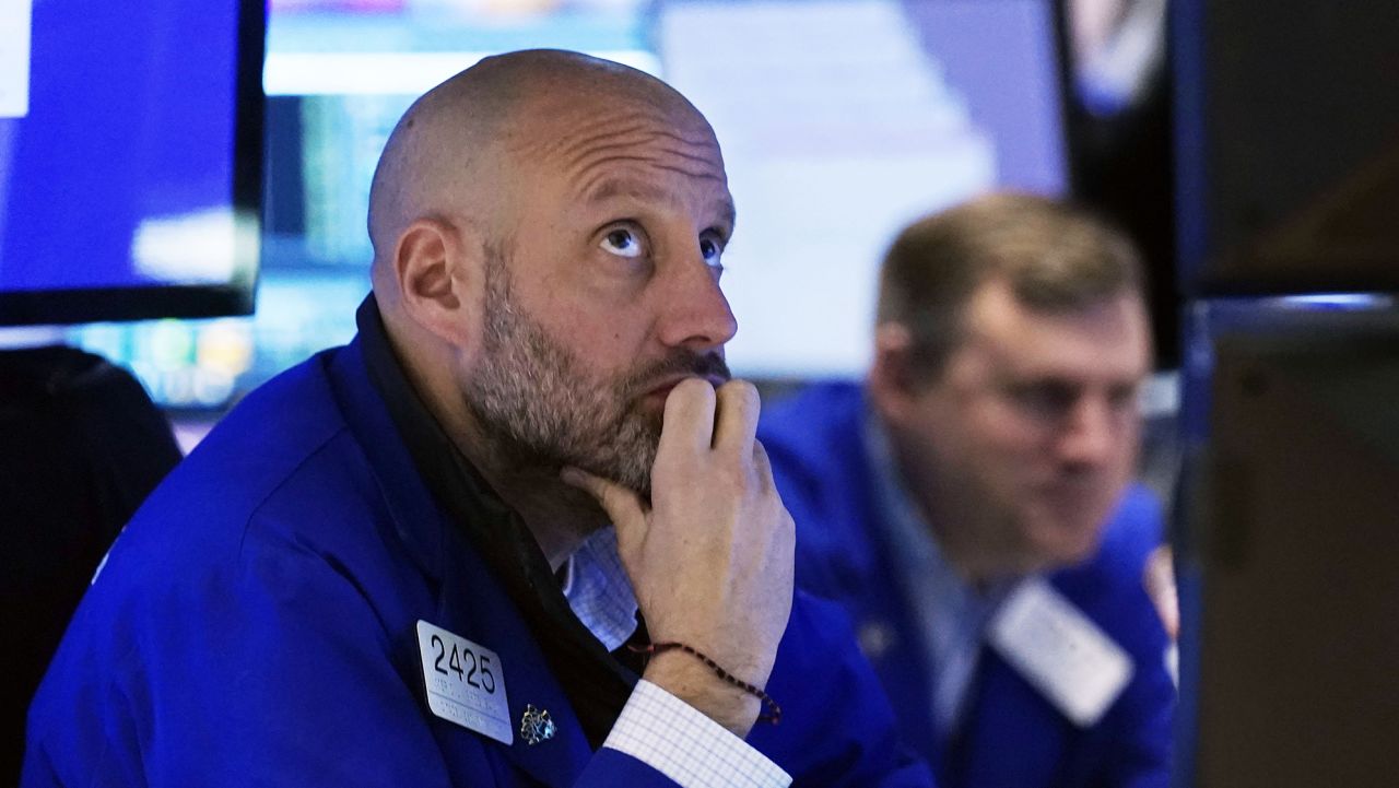 Specialist Meric Greenbaum, left, works at his post on the floor of the New York Stock Exchange, Friday, Nov. 26, 2021.