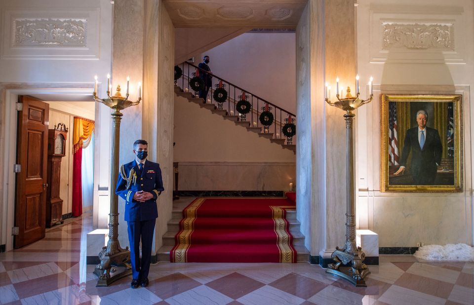 A White House social aide stands in the Grand Foyer.