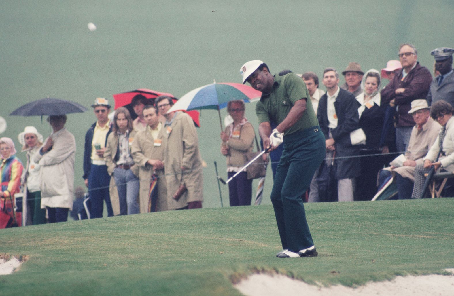 Elder watches a chip shot at the 1975 Masters. Elder broke into the game during the 1960s and 70s, a notoriously volatile period for race relations in the United States. At one tournament, he had been forced to change in the parking lot after being refused entry to the clubhouse; during another, his ball had been hurled into a hedge by a spectator.