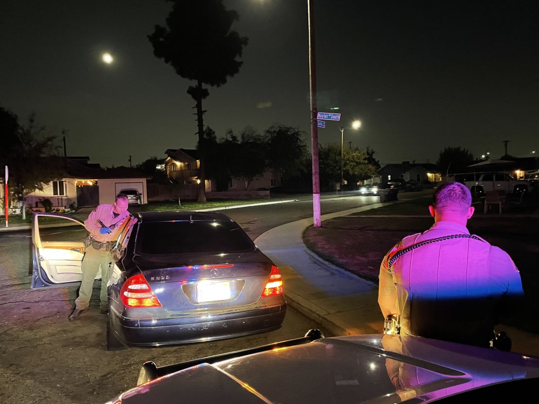 A deputy searches a car in Fresno. Getting pricked by a drug needle is a common hazard. 
