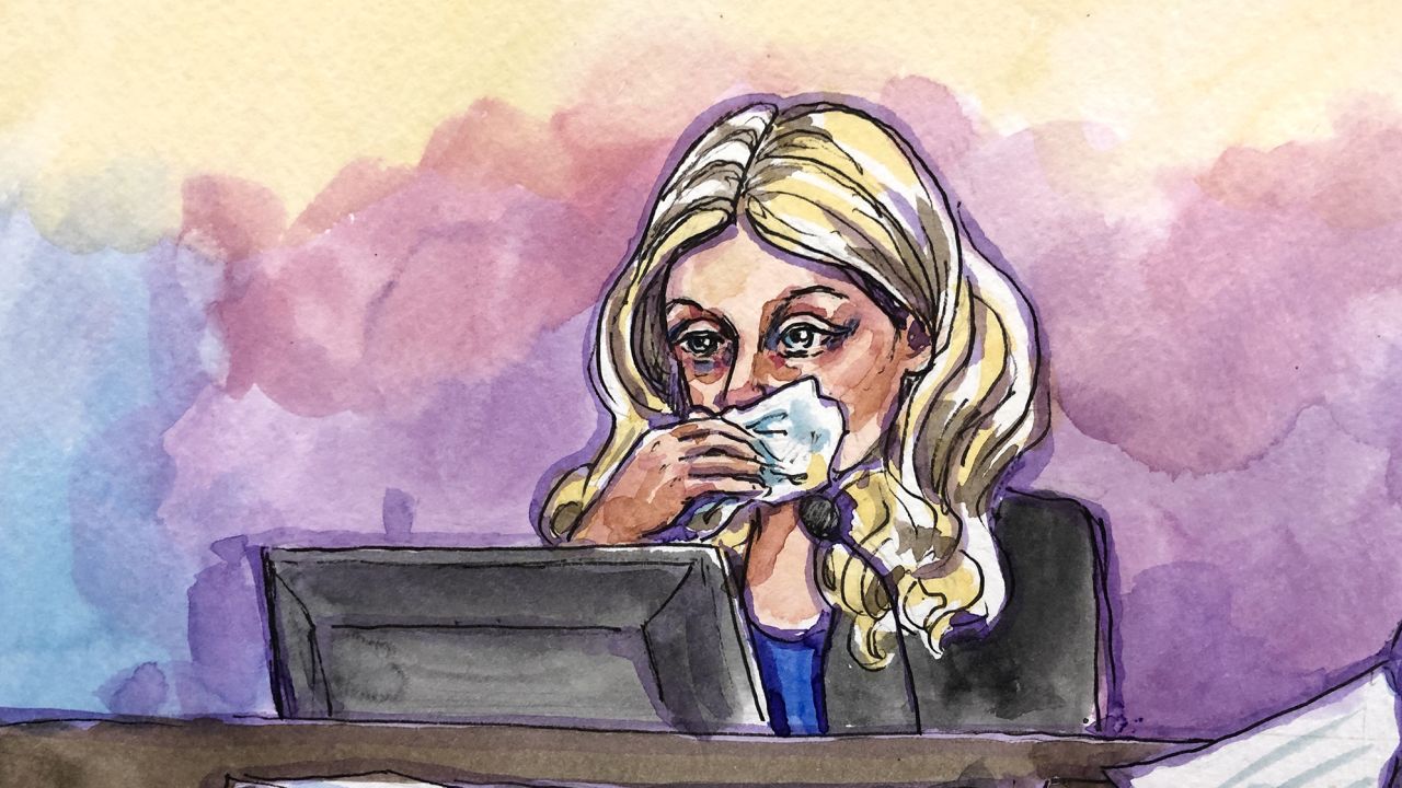 Elizabeth Holmes reacts during cross-examination at the federal court in San Jose, California, on Tuesday, November 30, as she was asked to read texts between her and former Theranos COO Ramesh "Sunny" Balwani.