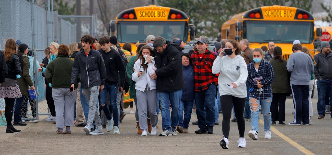 Parents walk with their children away from the Meijer parking lot, where many students gathered.