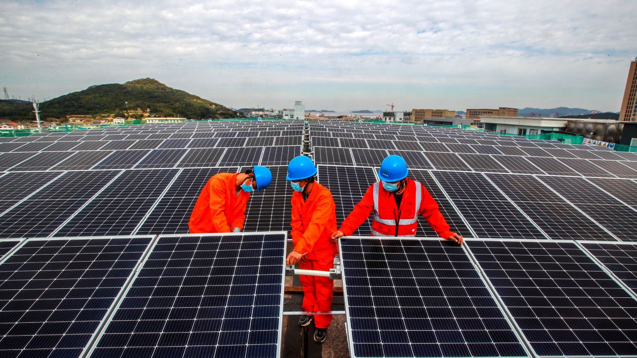 ZHOUSHAN, CHINA - NOVEMBER 16: Workers install photovoltaic panels on the roof of a fish processing plant on November 16, 2021 in Zhoushan, Zhejiang Province of China. (Photo by Yao Feng/VCG via Getty Images)