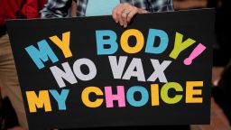 A woman holds a sign as several hundred anti-mandate demonstrators rally outside the Capitol during a special legislative session considering bills targeting COVID-19 vaccine mandates, Tuesday, Nov. 16, 2021, in Tallahassee, Florida. 