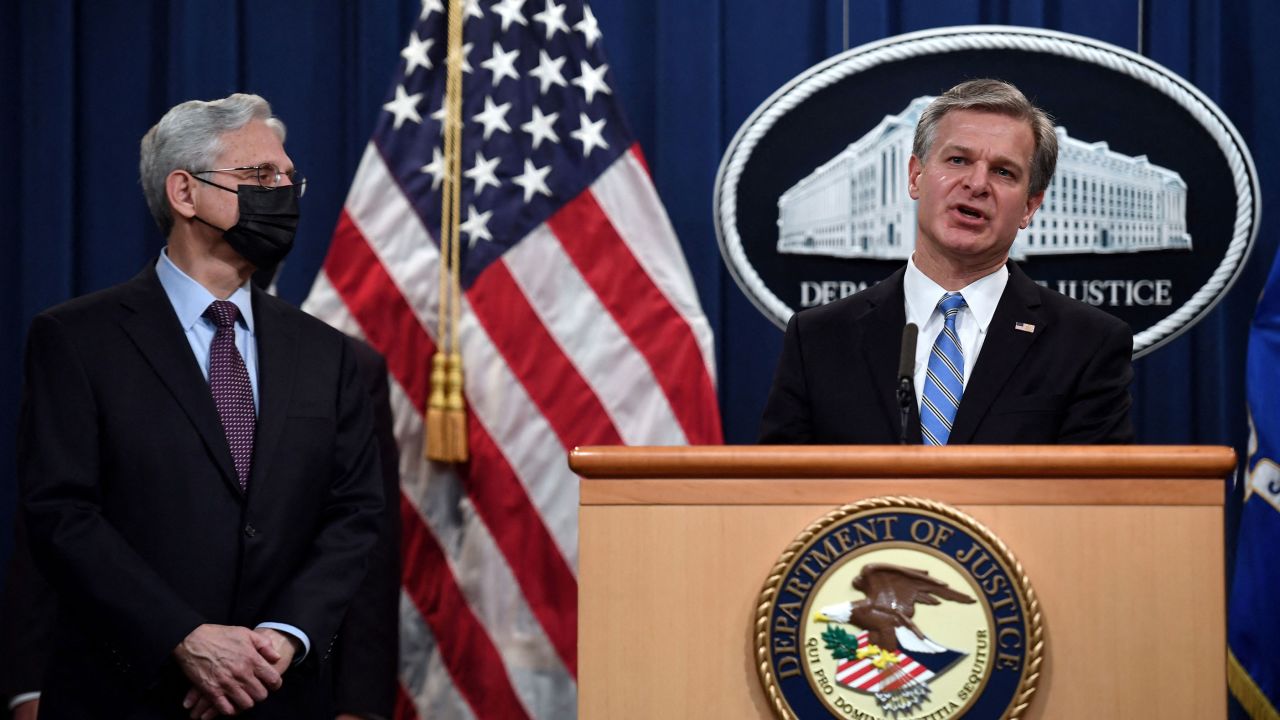 Attorney General Merrick Garland listens to FBI Director Christopher Wray speak during a news conference on ransomware cyberattacks at the Department of Justice in Washington on November 8, 2021.