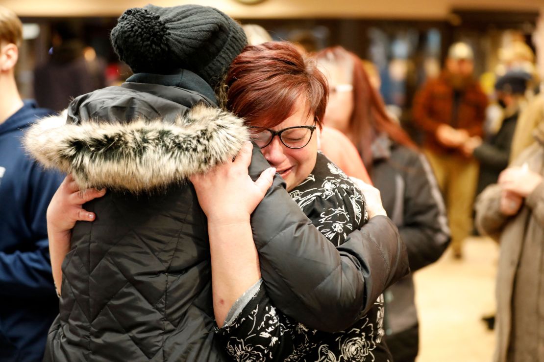 People hug during a vigil Tuesday following a shooting at Oxford High School in Michigan.