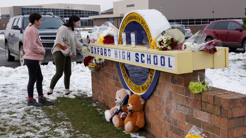 Students leave flowers at the sign of Oxford High School where memorial items are being placed in Oxford, Mich., Wednesday, Dec. 1, 2021. A 15-year-old sophomore opened fire at the school, killing several students and wounding multiple other people, including a teacher. (AP Photo/Paul Sancya)