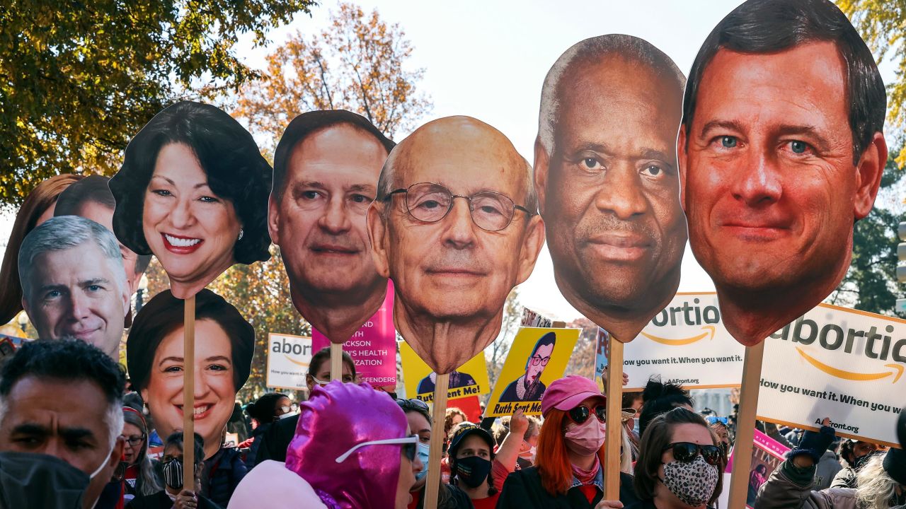 Activists with The Center for Popular Democracy Action hold photos of U.S. Supreme Court justices as they block an intersection during a demonstration in front of the U.S. Supreme Court on December 01, 2021 in Washington, DC.