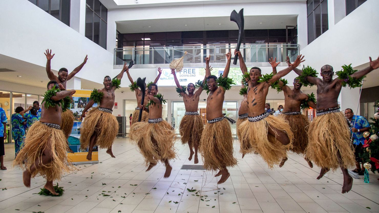 TOPSHOT - Traditional dancers in grass skirts welcome holidaymakers in Nadi on December 1, 2021, as Fiji opens its borders to international travellers for the first time since the Covid-19 pandemic swept the globe and devastated its tourism-reliant economy. (Photo by Leon LORD / AFP) (Photo by LEON LORD/AFP via Getty Images)
