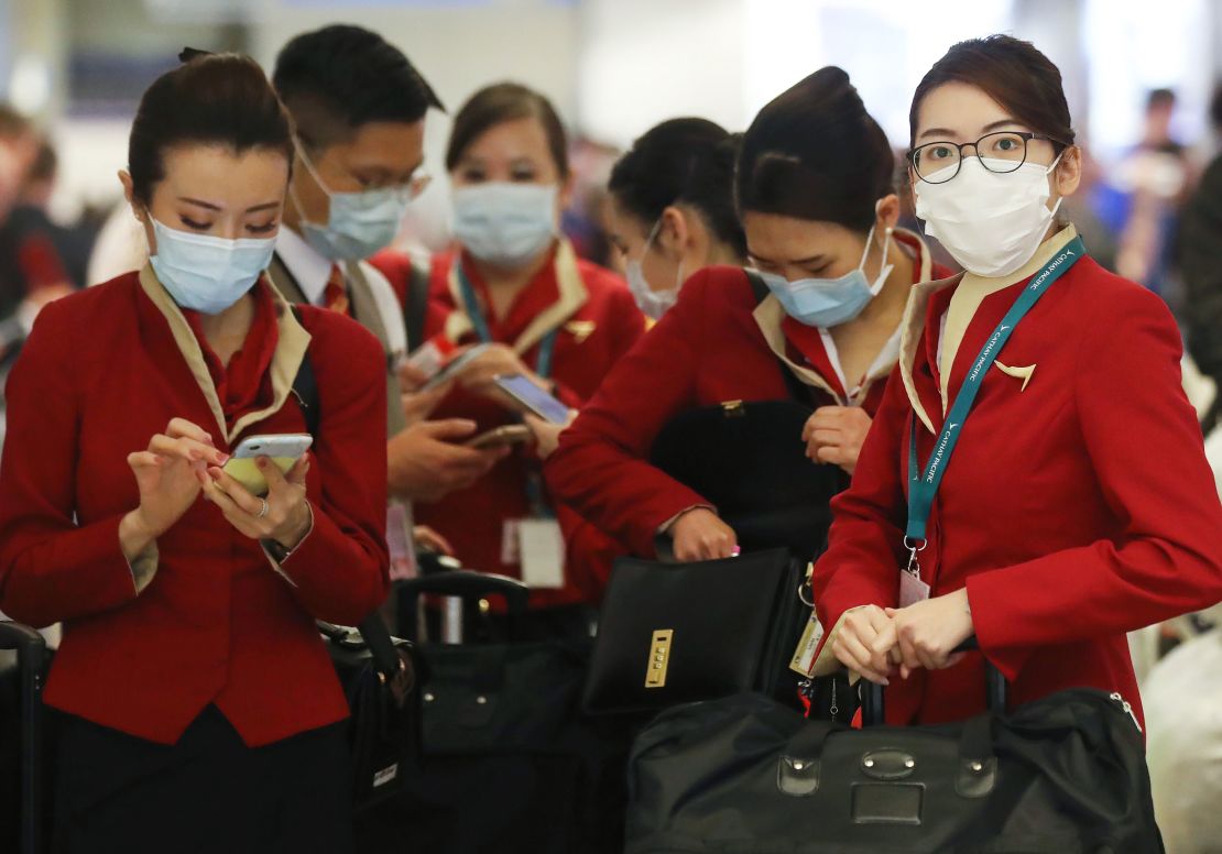 A flight crew from Cathay Pacific standing in the international terminal after arriving on a flight from Hong Kong at Los Angeles International Airport in February 2020.