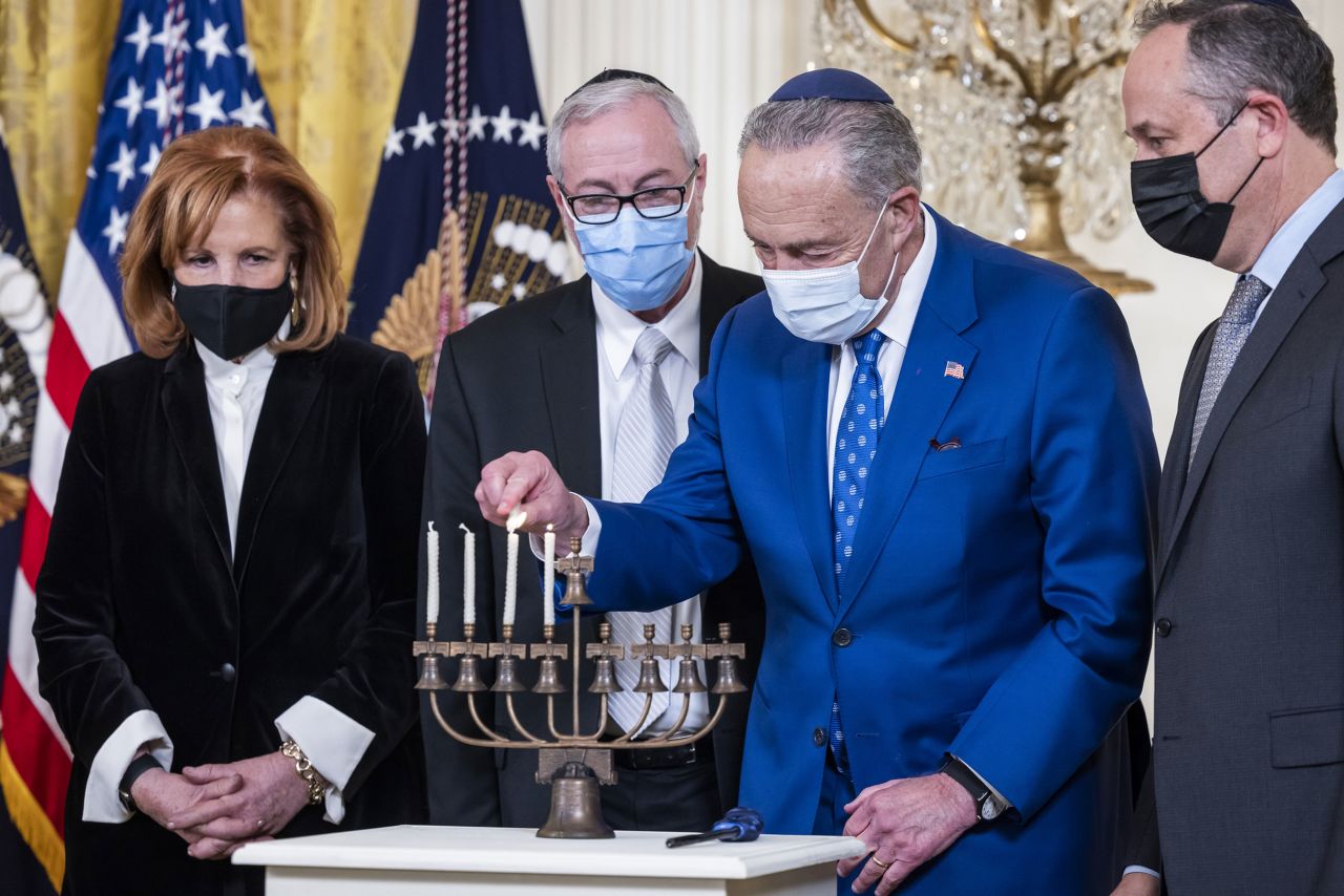 Senate Majority Leader Chuck Schumer lights a menorah during a <a href="https://www.cnn.com/2021/12/01/politics/biden-white-house-hanukkah/index.html" target="_blank">Hanukkah celebration at the White House</a> on Wednesday, December 1. He was joined, from left, by community leader Susan Stern, Rabbi Aaron Glatt and Doug Emhoff, the husband of Vice President Kamala Harris.